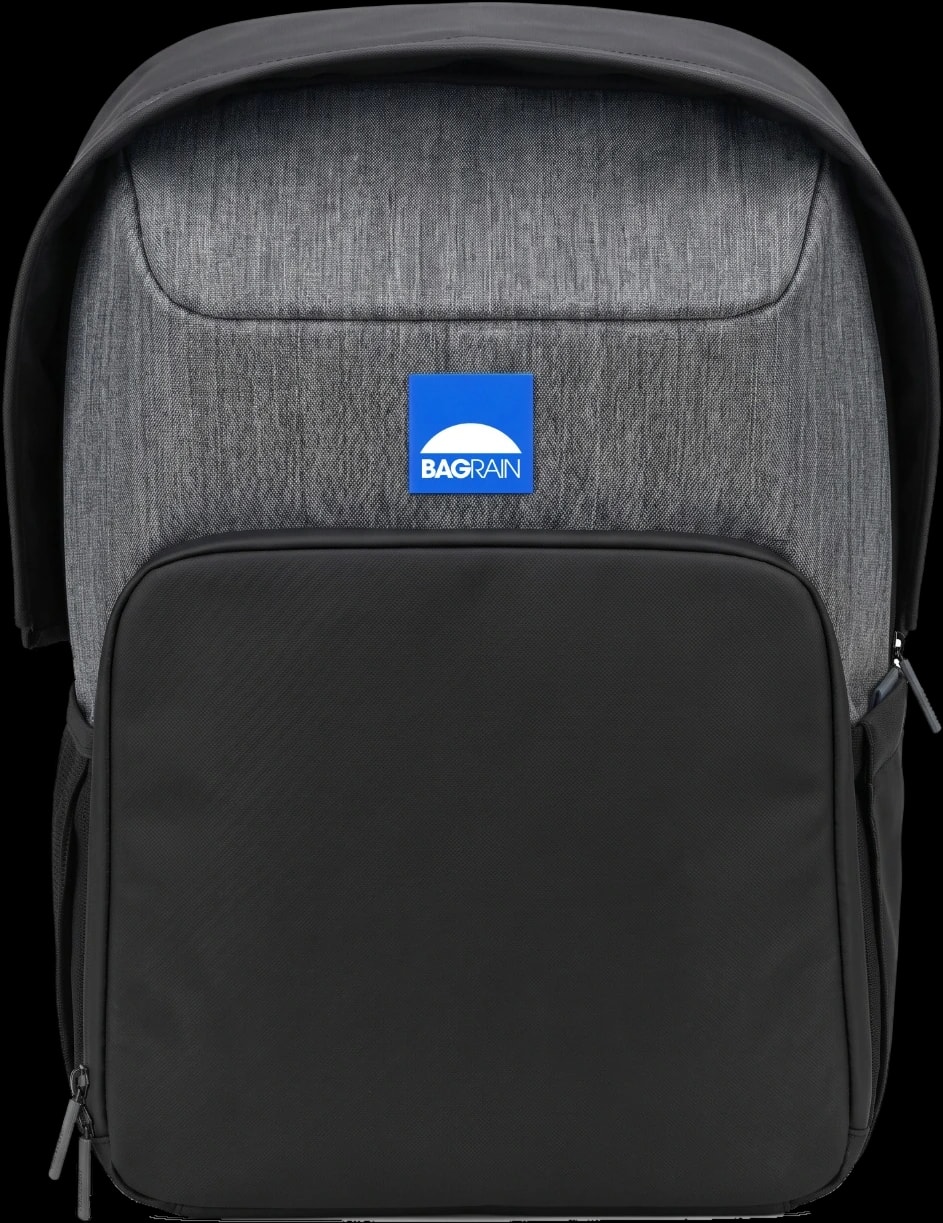 Sac à dos BAGRAIN vu de face : logo bleu sur le tissu gris, poche avant noire et capuche de pluie repliée en arceau au-dessus du sac